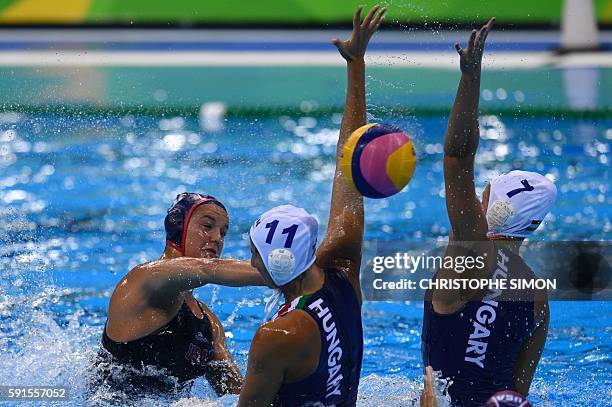 S Kiley Neushul aims at the goal to score marked by Hungary's Dora Csabai and Hungary's Anna Illes during their Rio 2016 Olympic Games women's water...