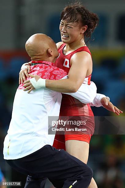 Eri Tosaka of Japan celebrates winning gold with coach Kazuhito Sakai over Mariya Stadnik of Azerbaijan in the Women's Freestyle 48kg event on Day 12...