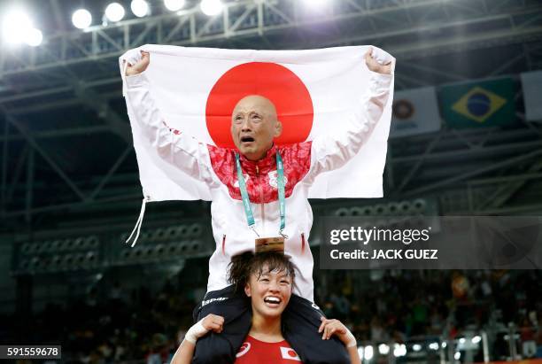 Japan's Eri Tosaka celebrates with her coach winning against Azerbaijan's Mariya Stadnyk in their women's 48kg freestyle final match on August 17...