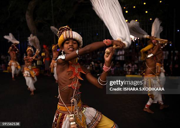 Sri Lanka's traditional dancers perform in front of the historic Buddhist Temple of the Tooth, as they take part in a procession during the Esala...