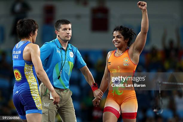 Sakshi Malik of India is declared the winner against Aisuluu Tynybekova of Kyrgyzstan during the Women's Freestyle 58 kg Bronze match on Day 12 of...