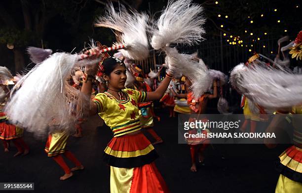 Sri Lanka's traditional dancers perform in front of the historic Buddhist Temple of the Tooth, as they take part in a procession during the Esala...
