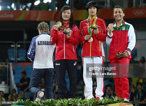 Silver medalist Mariya Stadnik of Azerbaijan walks off the podium as gold medalist Eri Tosaka of Japan, bronze medalist Yanan Sun of China and bronze...