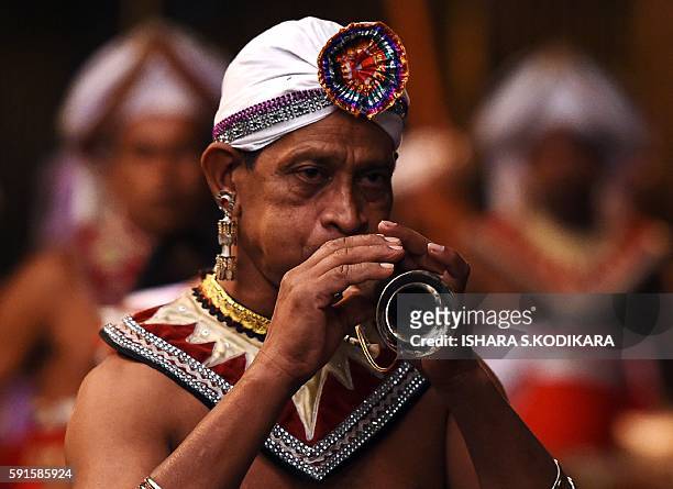 Sri Lanka's traditional dancer plays traditional music and performs in front of the historic Buddhist Temple of the Tooth, as he takes part in a...