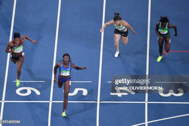 S Nia Ali crosses the finish line ahead of Canada's Phylicia George and Germany's Nadine Hildebrand and Nigeria's Oluwatobiloba Amusan in the Women's...