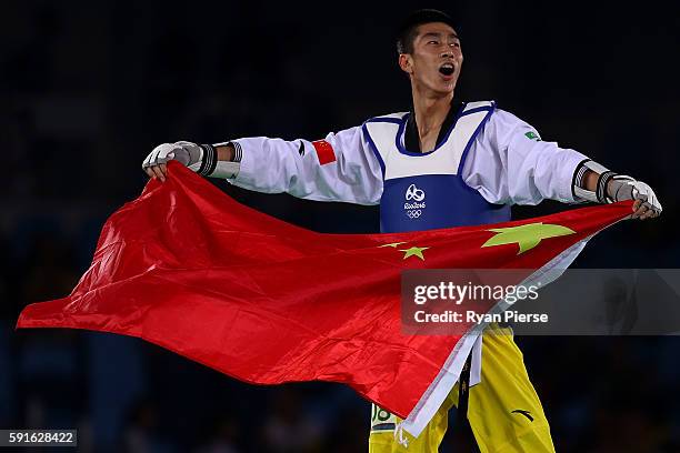 Shuai Zhao of China celebrates after winning gold over Tawin Hanprab of Thailand in the Taekwondo Men's -58kg contest during Day 12 of the Rio 2016...