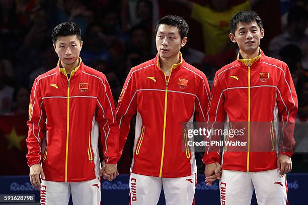 Gold medalists Long Ma, Xin Xu, and Jike Zhang of China celebrate during the medals ceremony after the Men's Table Tennis gold medal match against...