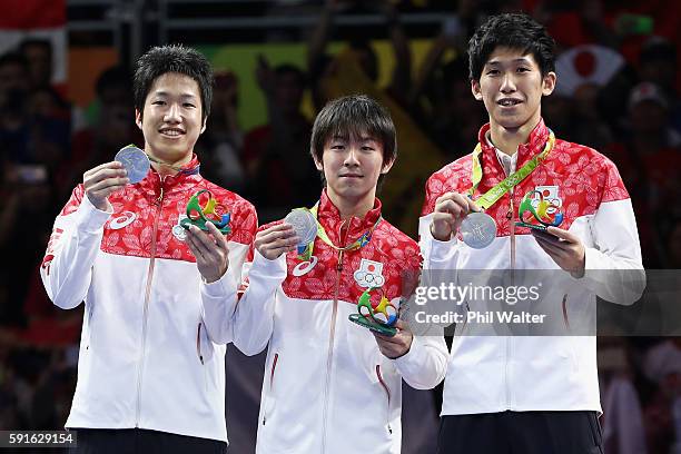 Silver medalists Jun Mizutani, Maharu Yoshimura and Koki Niwa of Japan celebrate during the medal ceremony after the Men's Team Table Tennis gold...