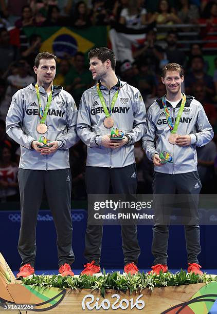 Bronze medalists Timo Boll, Dimitrij Ovtcharov, and Bastian Steger of Germany celebrate on the podium during the Men's Team Table Tennis medal...