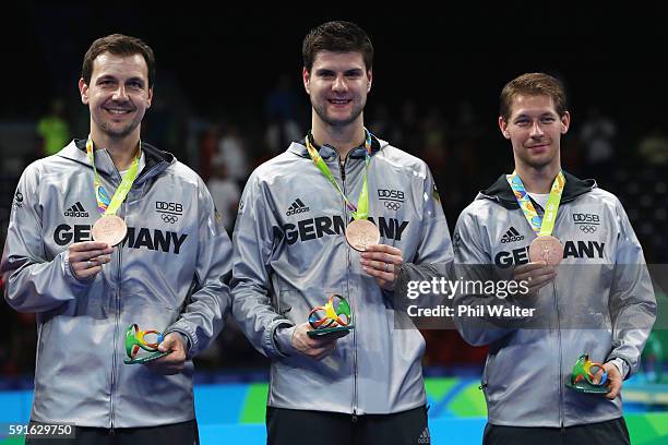 Bronze medalists Timo Boll, Dimitrij Ovtcharov, and Bastian Steger of Germany celebrate on the podium during the Men's Team Table Tennis medal...
