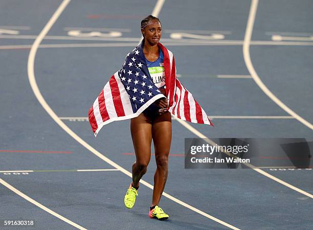 Brianna Rollins of the United States reacts with the American flag after winning the gold medal in the Women's 100m Hurdles Final on Day 12 of the...