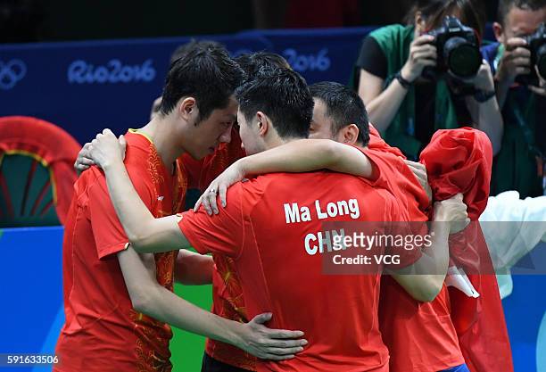 Xu Xin, Zhang Jike, coach Liu Guoliang and Ma Long of China celebrate after beating Japanese team during the Men's Table Tennis gold medal match on...