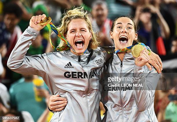 Germany's gold medallists, Laura Ludwig and Kira Walkenhorst, celebrate on the podium at the end of the women's beach volleyball event at the Beach...
