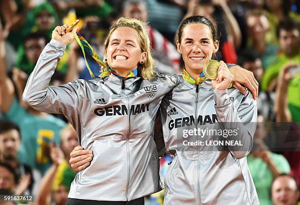 Germany's gold medallists, Laura Ludwig and Kira Walkenhorst, celebrate on the podium at the end of the women's beach volleyball event at the Beach...