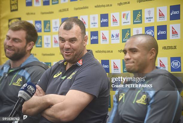 Australian rugby coach Michael Cheika answers a question flanked by Will Genia and Ben McCalman after announcing his squad for the upcoming the...