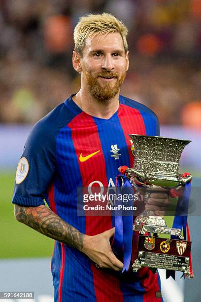 Barcelona's Leo MEssi hold the trophy of the Spanish Super Cup football match between FC Barcelona and Sevilla FC at Camp Nou Stadium on August 17,...