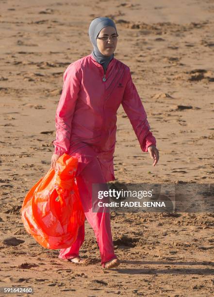 Moroccan woman wearing a "burkini", a full-body swimsuit designed for Muslim women, walks at Oued Charrat beach, near the capital Rabat, on August...