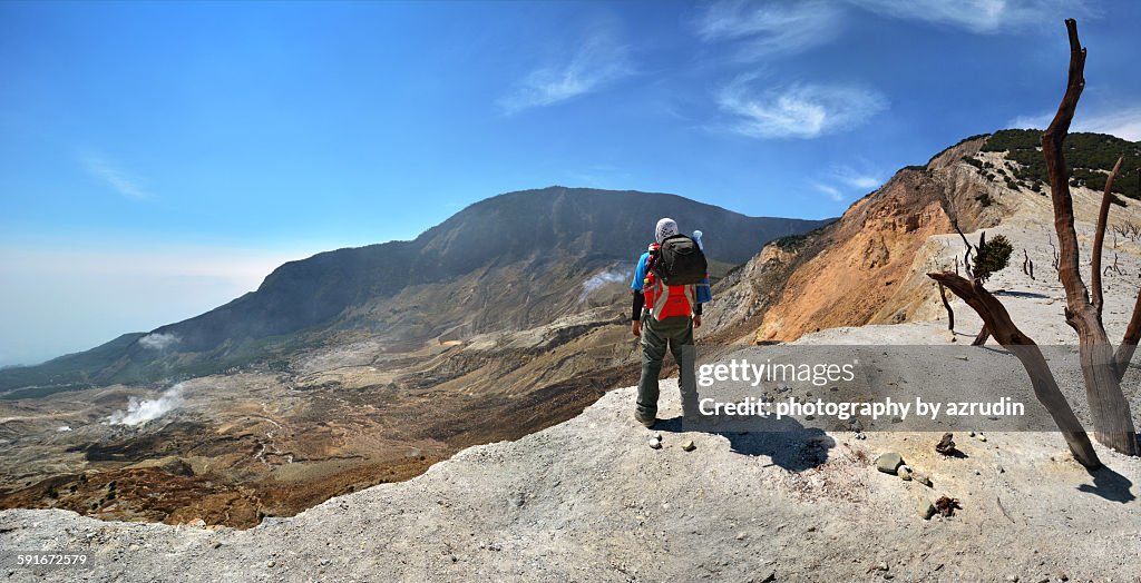 Panorama view of hiker at the peak of mount