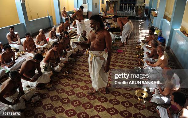 Priest chants manthras as members of the Hindu Brahmin community perform an annual ritual on occasion of Avani Avittam in Chennai on August 18,2016....
