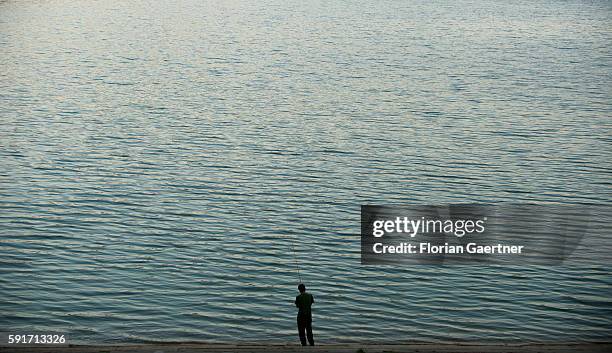 An angler fishs at the artificial lake of Bezid on August 04, 2015 in Bezid, Romania.