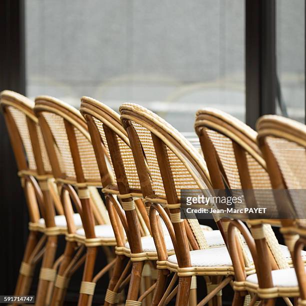 typical chairs of a sidewalk cafe of paris - jean marc payet stock-fotos und bilder