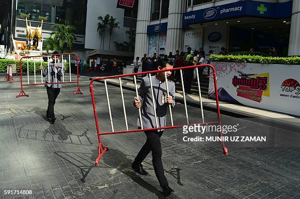 Thai workers carry away barricades after police disposed of a suspicious bag during a false bomb scare in the tourist-heavy Ratchaprasong district in...