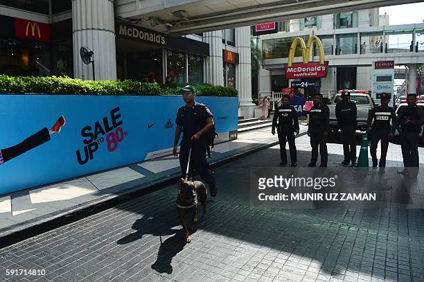 Thai soldiers walk with a sniffer after police disposed of a suspicious bag during a false bomb scare in the tourist-heavy Ratchaprasong district in...