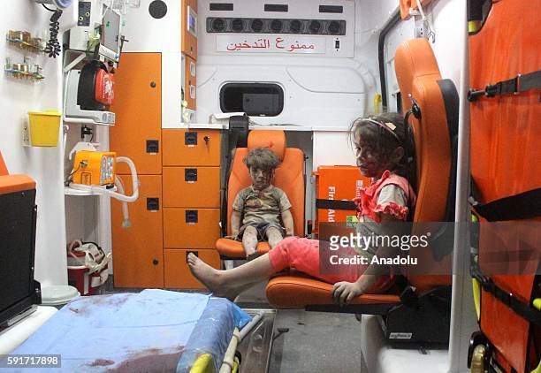 Year-old wounded Syrian kid Omran Daqneesh sits with his sister in the back of the ambulance after they got injured during Russian or Assad regime...