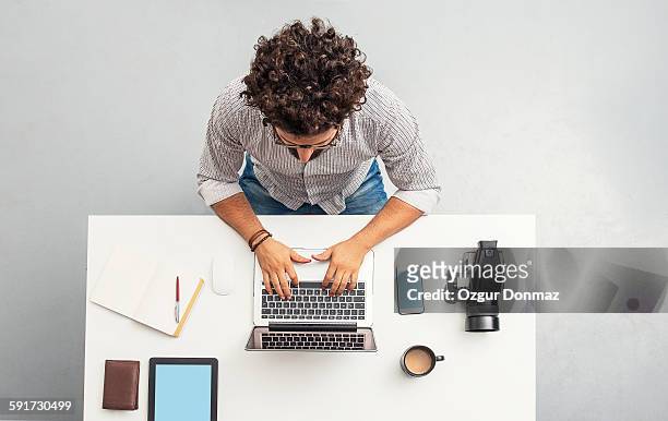 man working at home office with laptop - overhead view fotografías e imágenes de stock