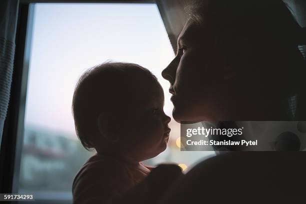 silhouette of mother kissing daughter - head silhouette stock pictures, royalty-free photos & images