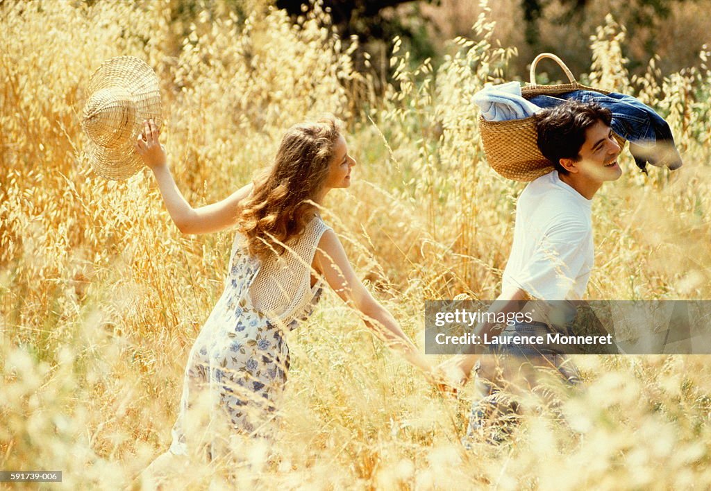 Couple walking through summer meadow