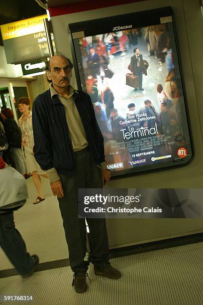 Mehran Karimi Nasseri, who prefers to be known as "Sir Alfred", stands in front of a poster of Steven Spielberg's movie "The Terminal" loosely based...