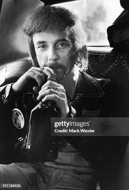 Rock & Roll songwriter and record producer, Phil Spector nurses a bottle of liquor while being driven through the Hollywood Hills after a recording...