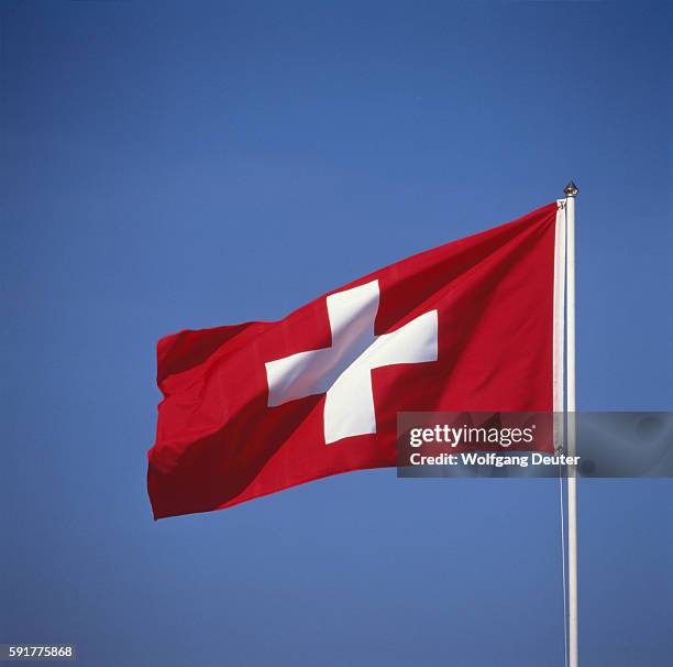 national flag of switzerland against blue sky - swiss flag stockfoto's en -beelden