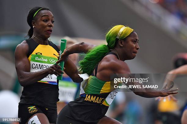 Jamaica's Shelly-Ann Fraser-Pryce grabs the baton from Jamaica's Veronica Campbell-Brown as they compete in the Women's 4 x 100m Relay Round 1 during...