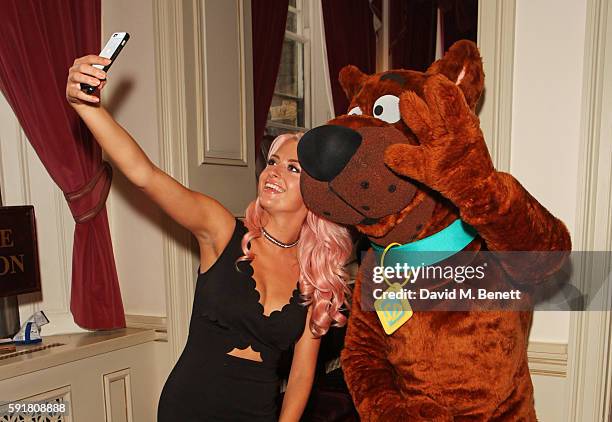 Chloe Paige poses with Scooby-Doo at the press night after party for "Scooby-Doo Live! Musical Mysteries" at The London Palladium on August 18, 2016...