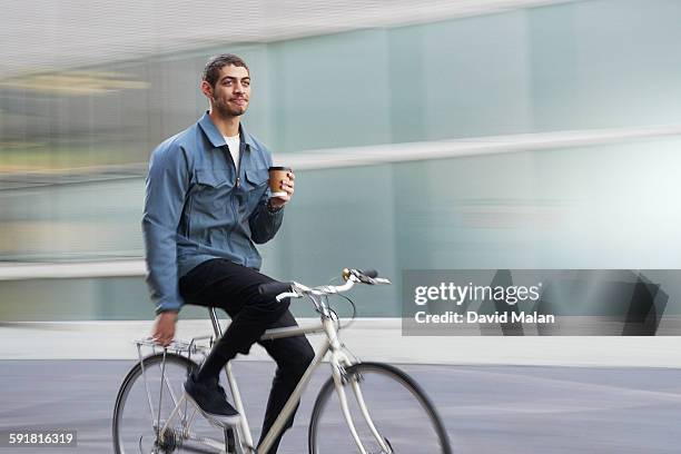 commuter cyclist with coffee (soft background) - coffee bike stock pictures, royalty-free photos & images