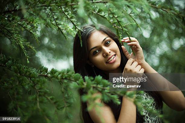 schöne mädchen zwischen der natur voller zweige von kiefer. - indian beautiful girls stock-fotos und bilder