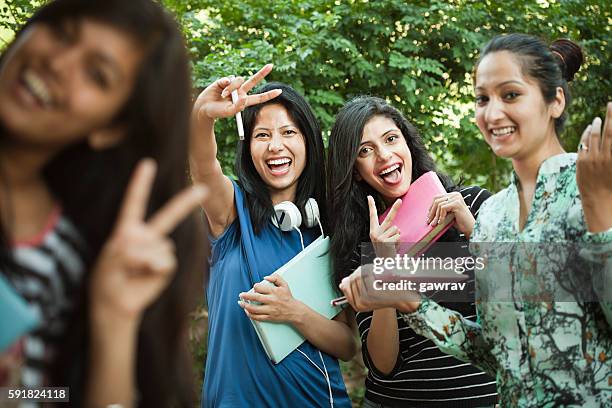 gruppe von glücklichen mädchen studenten zeigen frieden handzeichen. - day 16 stock-fotos und bilder