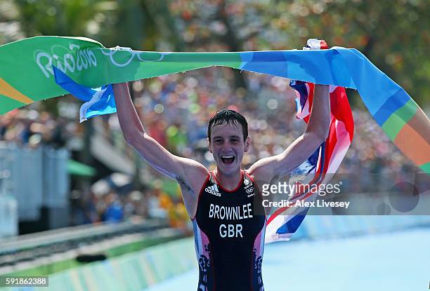 Alistair Brownlee of Great Britain celebrates as he crosses the finish line during the Men's Triathlon at Fort Copacabana on Day 13 of the 2016 Rio...
