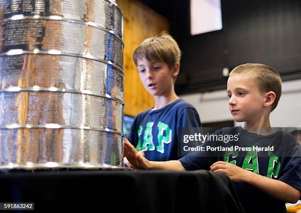 Landon Brown of Auburn, gets his chance to touch the Stanley Cup after having his photo taken with it at the Biddeford Arena.