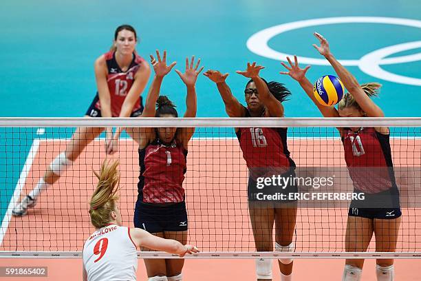 S Alisha Glass, USA's Foluke Akinradewo and USA's Jordan Larson-Burbach jump up to block the ball during the women's semi-final volleyball match...