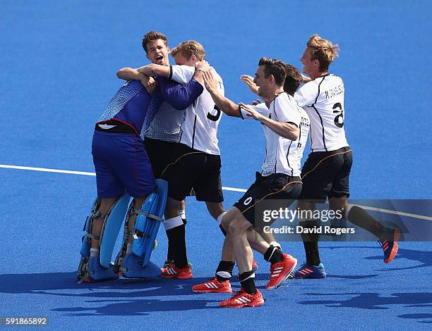 Nicolas Jacobi the Germany goalkeeper is mobbed by team mates after saving the shot from Sander de Wijn to win the penalty shoot out during the Men's...