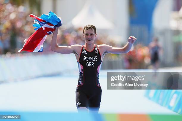 Alistair Brownlee of Great Britain celebrates after crossing the finish line during the Men's Triathlon at Fort Copacabana on Day 13 of the 2016 Rio...