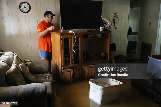 Denny Lazarus and Trina Fouchi help salvage what they can from their parents flooded home on August 18, 2016 in St Amant, Louisiana. Last week...