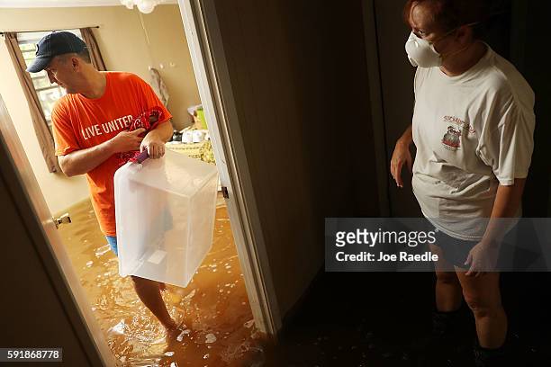 Denny Lazarus and Trina Fouchi help salvage what they can from their parents flooded home on August 18, 2016 in St Amant, Louisiana. Last week...