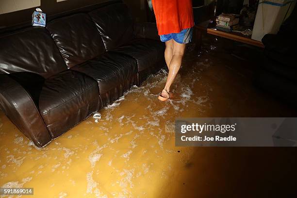 Denny Lazarus walks though the flooded living room as he helps salvage what he can from his parents home on August 18, 2016 in St Amant, Louisiana....
