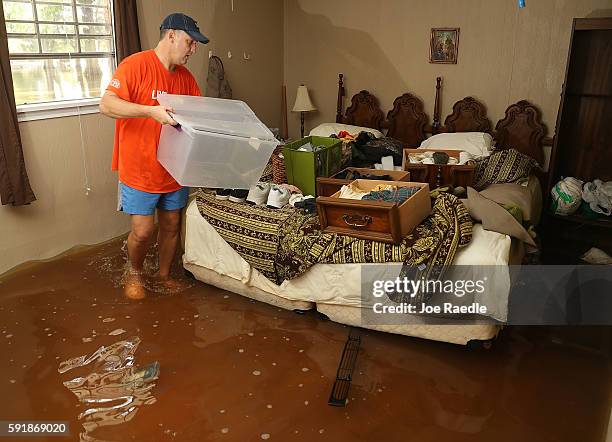 Denny Lazarus helps salvage what he can from his parents flooded home on August 18, 2016 in St Amant, Louisiana. Last week Louisiana was overwhelmed...