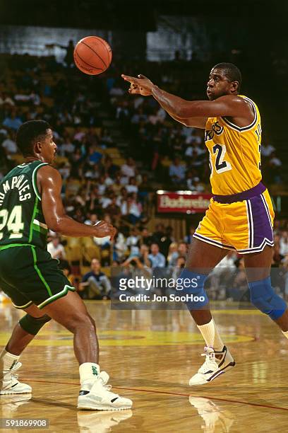 Magic Johnson of the Los Angeles Lakers passes the ball against the Milwaukee Bucks at the Great Western Forum on March 22, 1991 in Inglewood,...