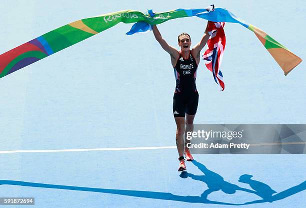 Alistair Brownlee of Great Britain celebrates after crossing the finish line during the Men's Triathlon at Fort Copacabana on Day 13 of the 2016 Rio...